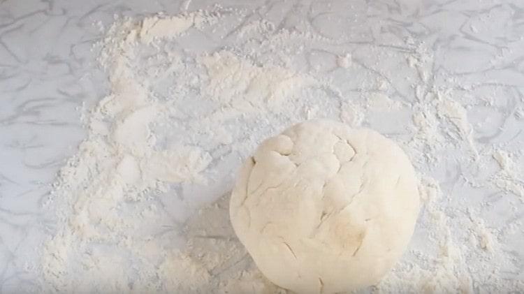 Nous roulons la pâte dans la farine, formant une boule.