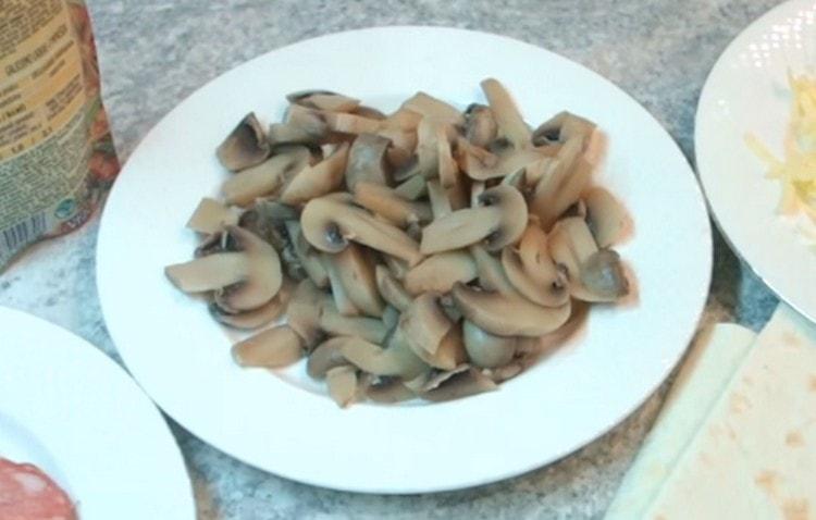 Boil the champignons in salted water and cut them into thin slices.