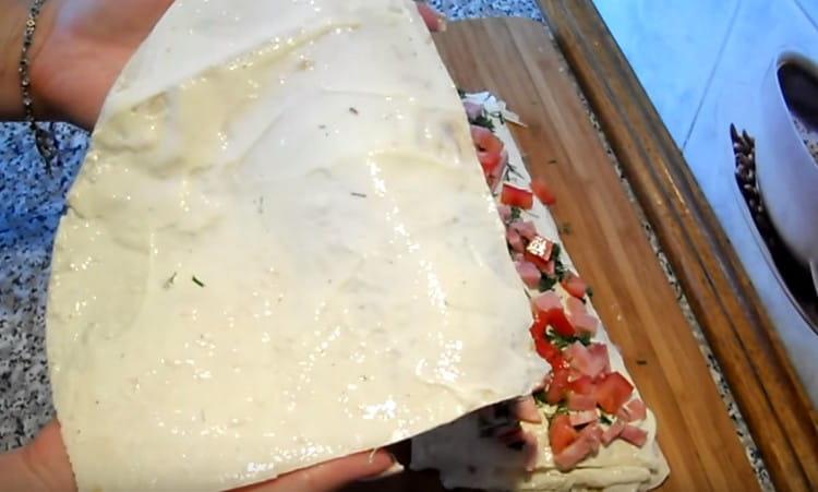 Lubricate the last part of pita bread with the remaining cheese and cover it with the workpiece.