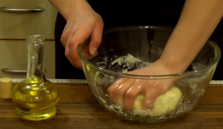 Kneading the dough, add olive oil to it.