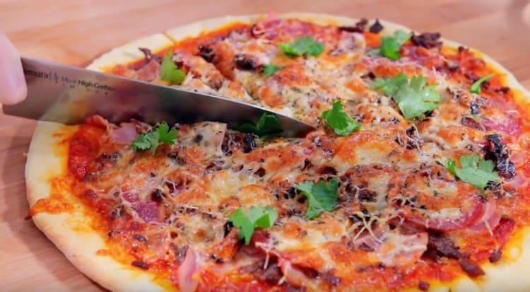 Wonderful meat pizza can be garnished with fresh herbs when served.