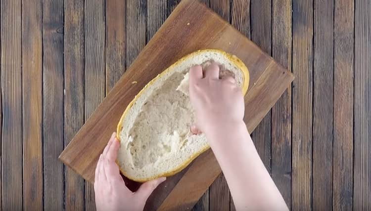 Couper le pain en deux et retirer la miette du bas.