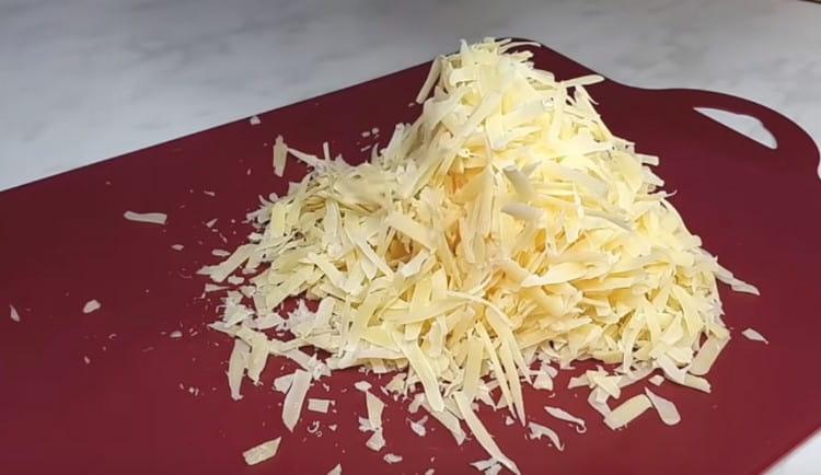 Rallar el queso en un rallador.