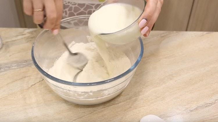 Add kefir to flour and mix the dough.