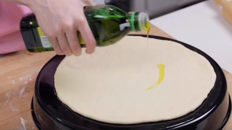 we spread the dough on a baking sheet greased with vegetable oil, on top we also grease with oil.