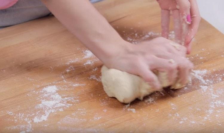 Ensuite, pétrissez la pâte directement sur la surface de travail en la saupoudrant de farine.