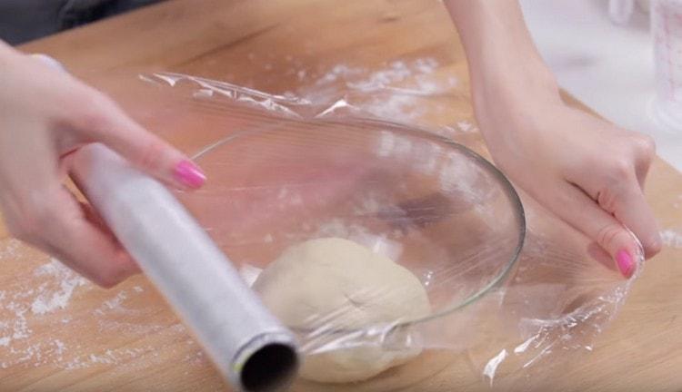 On étale la pâte avec un bol graissé, on recouvre d'un film et on la laisse au chaud.