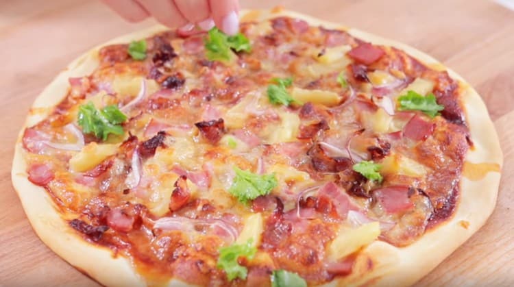 Si vous le souhaitez, une pizza prête à l'emploi à l'ananas peut être décorée avec de la coriandre.