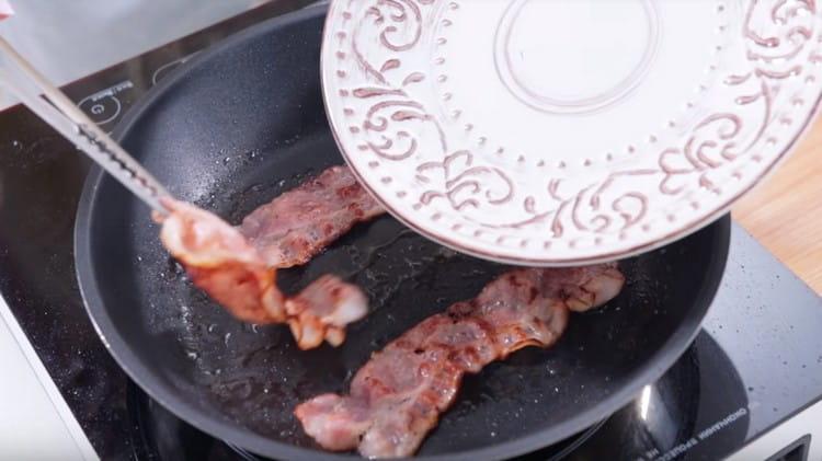 Faire frire des tranches de bacon dans une poêle.