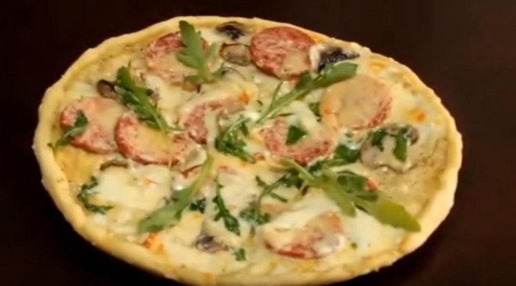 La pizza con salchicha al final de la cocción también debe espolvorearse con parmesano.