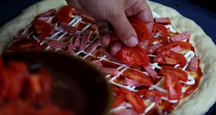 Nous étalons des tranches de tomates sur le saucisson.