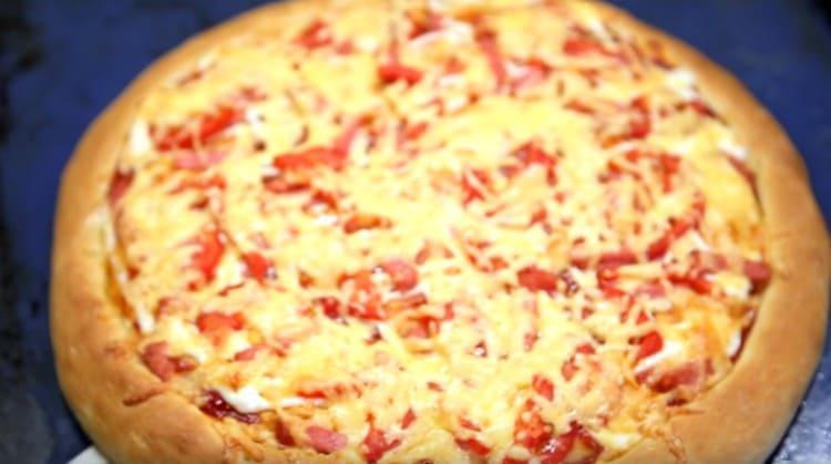 Pizza avec saucisse et fromage et tomates est prêt!