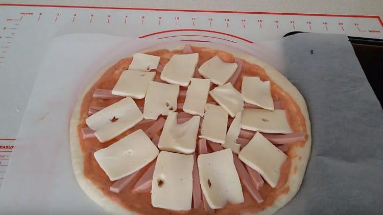 Put slices of mozzarella on the sausage.