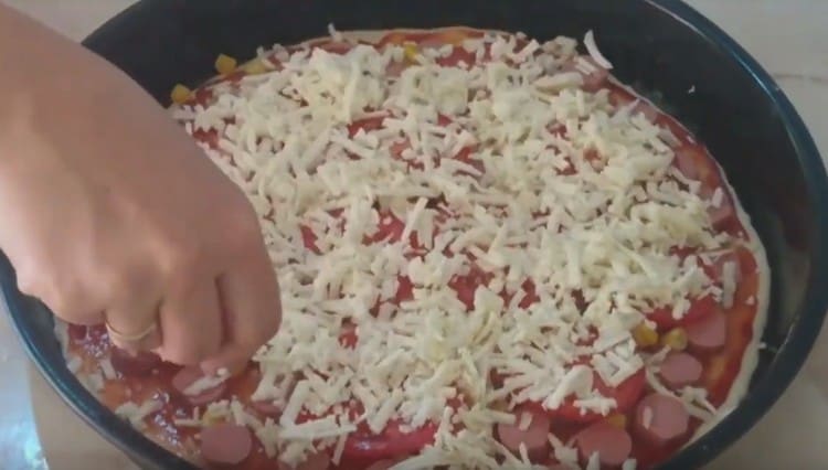 We spread sausages, corn, tomatoes, cheese sliced ​​in circles.