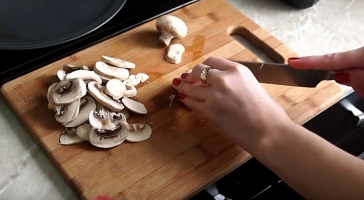 Nous nettoyons et coupons les champignons en tranches.