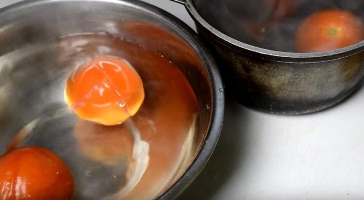 Immédiatement avec de l'eau bouillante, transférer les tomates dans de l'eau froide.