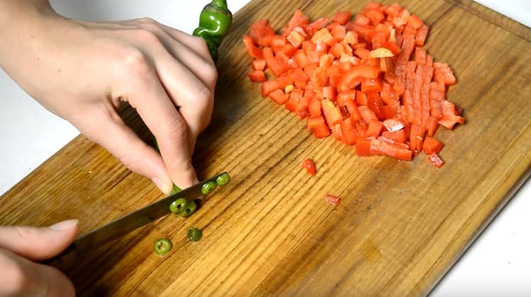 Izrežite nekoliko kriški ljute paprike.