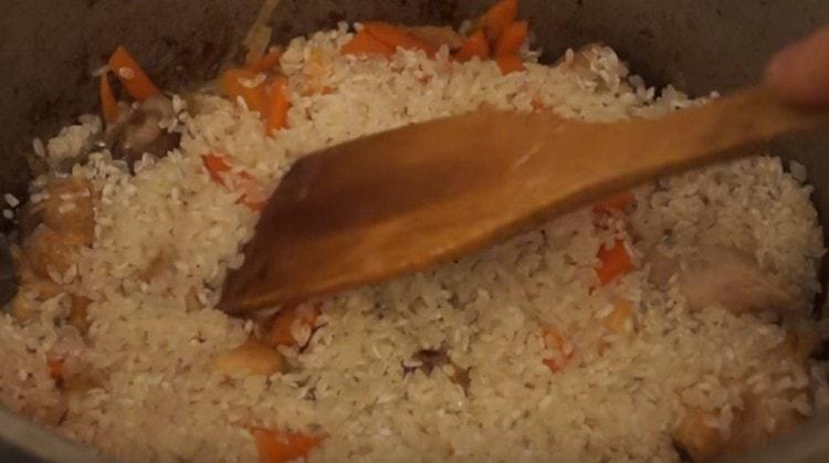 Encima de las verduras hay una capa de arroz lavado.