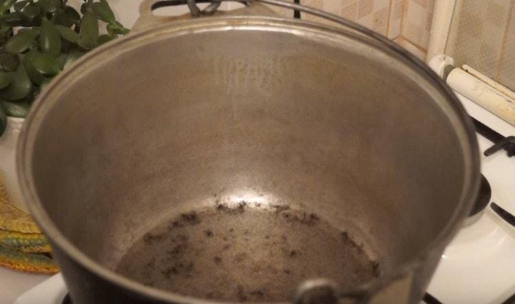 We heat vegetable oil in a cauldron.