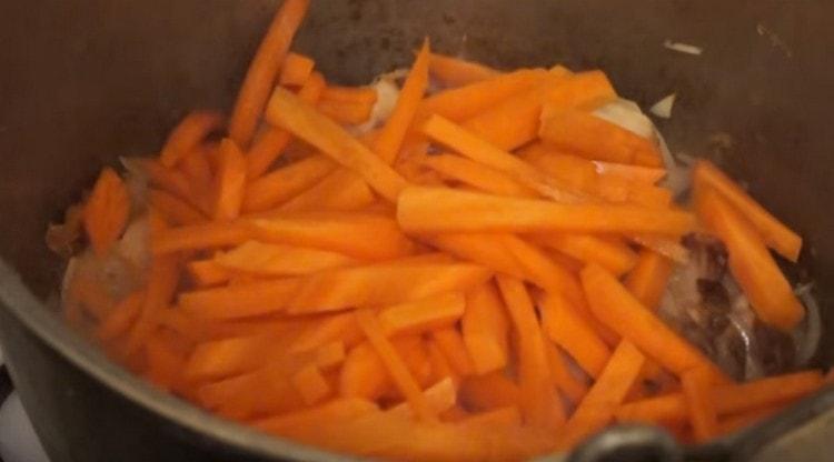 Tout d'abord, nous envoyons des oignons au chaudron pour la viande, puis des carottes.