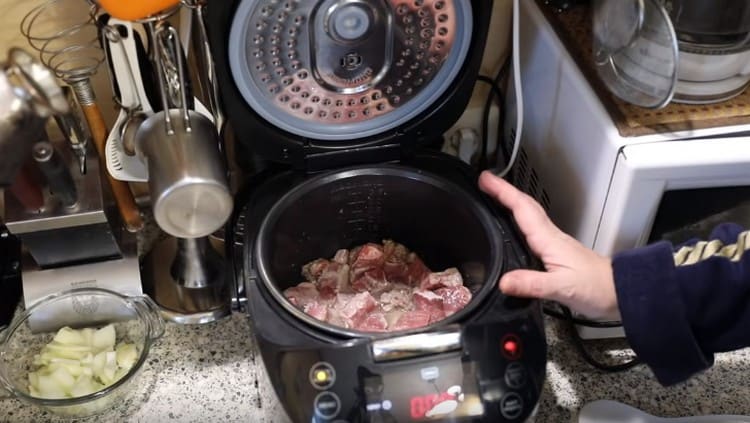 We spread the pork in the bowl of the multicooker and begin to fry.