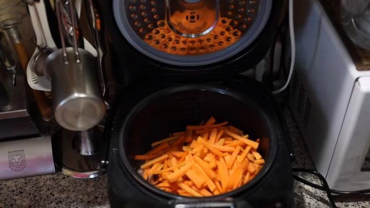 Corta las zanahorias en tiras finas y colócalas en el recipiente multicocina.