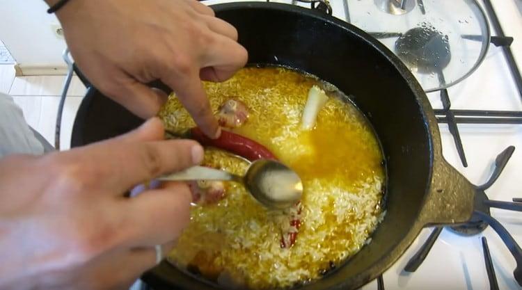 Agregue ajo al arroz, así como pimiento picante.