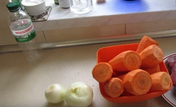 Pelar y picar cebollas y zanahorias.