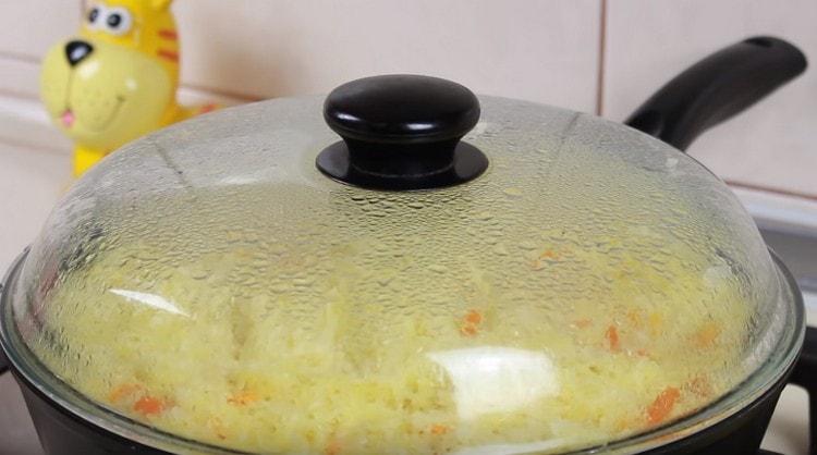 Cooking pilaf with chicken in a pan under the lid.