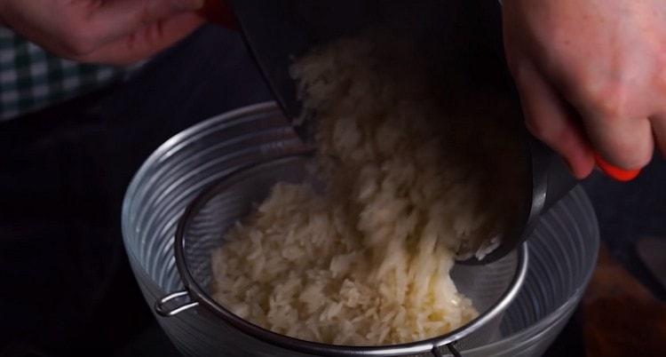 Nous jetons le riz sur un tamis, il devrait être un peu cuit.