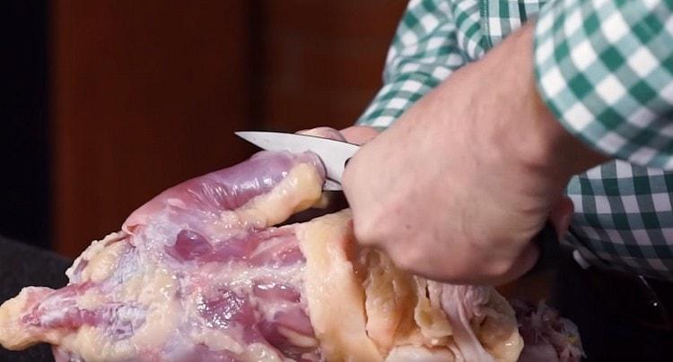 Separating the skin at the bottom of the carcass, cut off the lower legs with it, and leave the thigh.