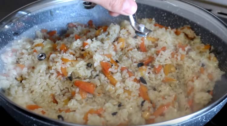 Mezcle el arroz con las verduras, cubra y deje que se prepare un poco más.