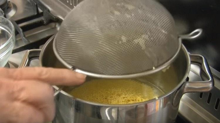 Dans une casserole, porter l'eau à ébullition et y mettre le mil.