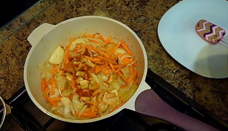 Nous hachons le poivron et ajoutons à la poêle les carottes et les oignons.