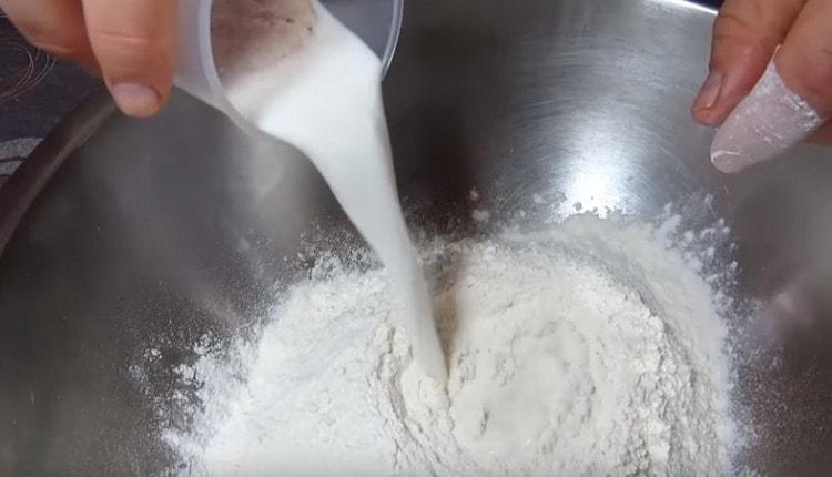 Dans la farine tamisée, nous introduisons du lait avec de la levure.