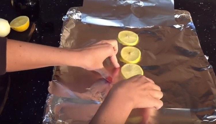 Recouvrez la plaque de cuisson de papier d'aluminium et placez des cercles de citron dessus.