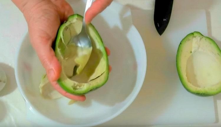 Gently spoon the avocado pulp and transfer to a bowl.