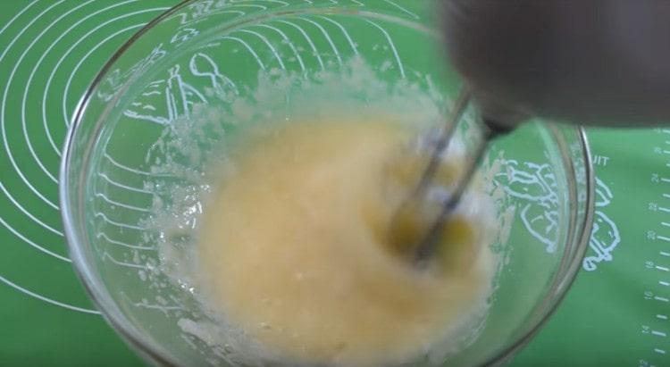 Batir los huevos con azúcar con una batidora.