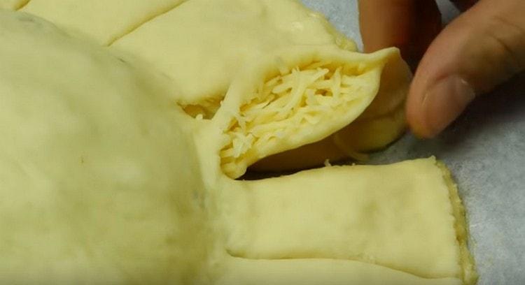 Gently rotate the edges of the dough, forming the petals of the future sunflower.