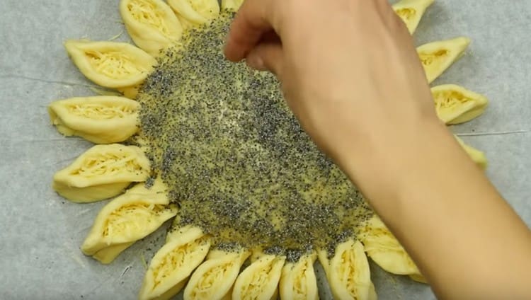 Grease the center of the pie with yolk and sprinkle with poppy seeds.