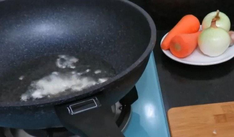 We heat the pan with vegetable oil, add chopped garlic.