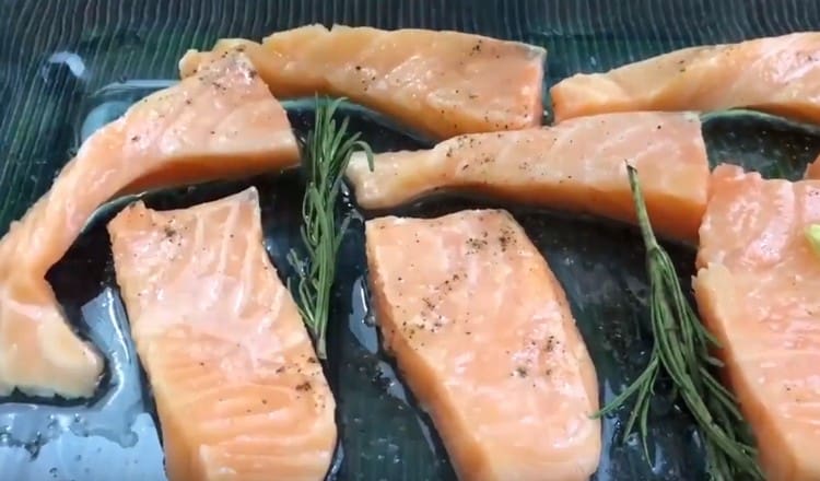 We lay the pieces of salmon on the grill of the oven, grease with olive oil, sprinkle with salt, pepper.