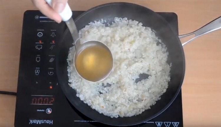 When the wine evaporates, add the soup ladle to the rice.