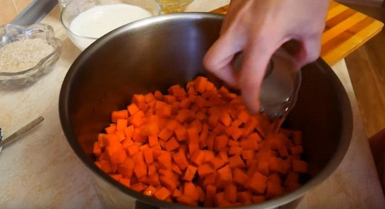 Nous répandons les morceaux de citrouille dans une casserole et le remplissons d'eau.