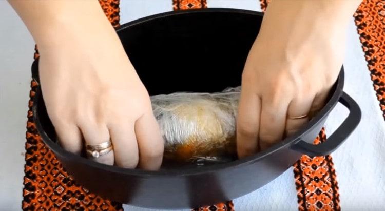 Wrapping the roll with cling film, put it in a saucepan.