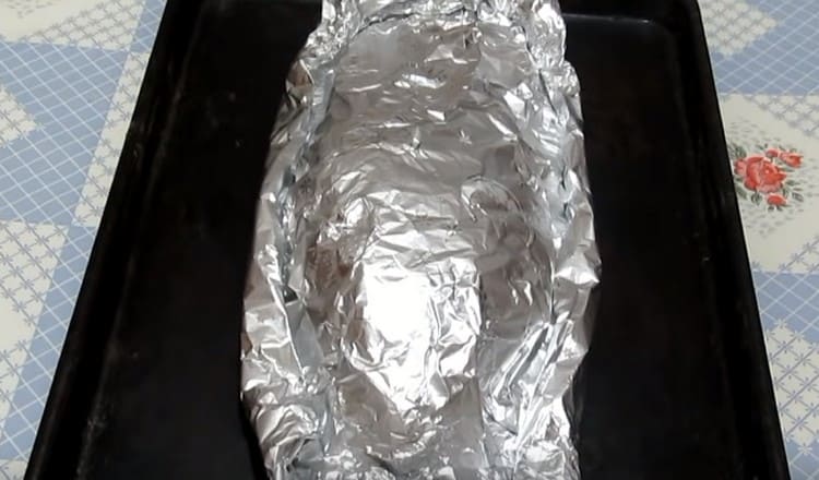 Gently transfer the fish in foil to a baking sheet and send it to the oven.