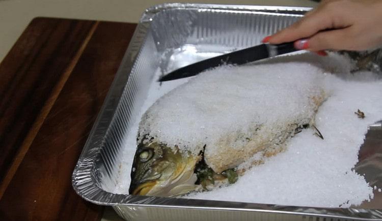 After baking, carefully remove the salt crust from the fish.