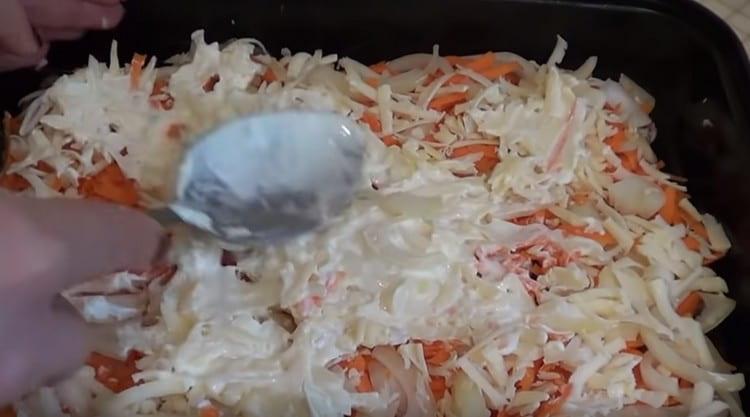 Saupoudrer une couche de légumes avec du fromage râpé et graisser à nouveau avec un peu de mayonnaise.