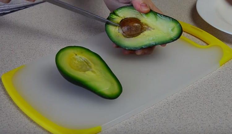 Cut the avocado in half and take out a stone.