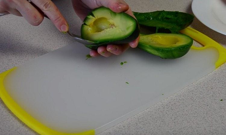 Using a teaspoon, remove the flesh of the avocado from the peel.